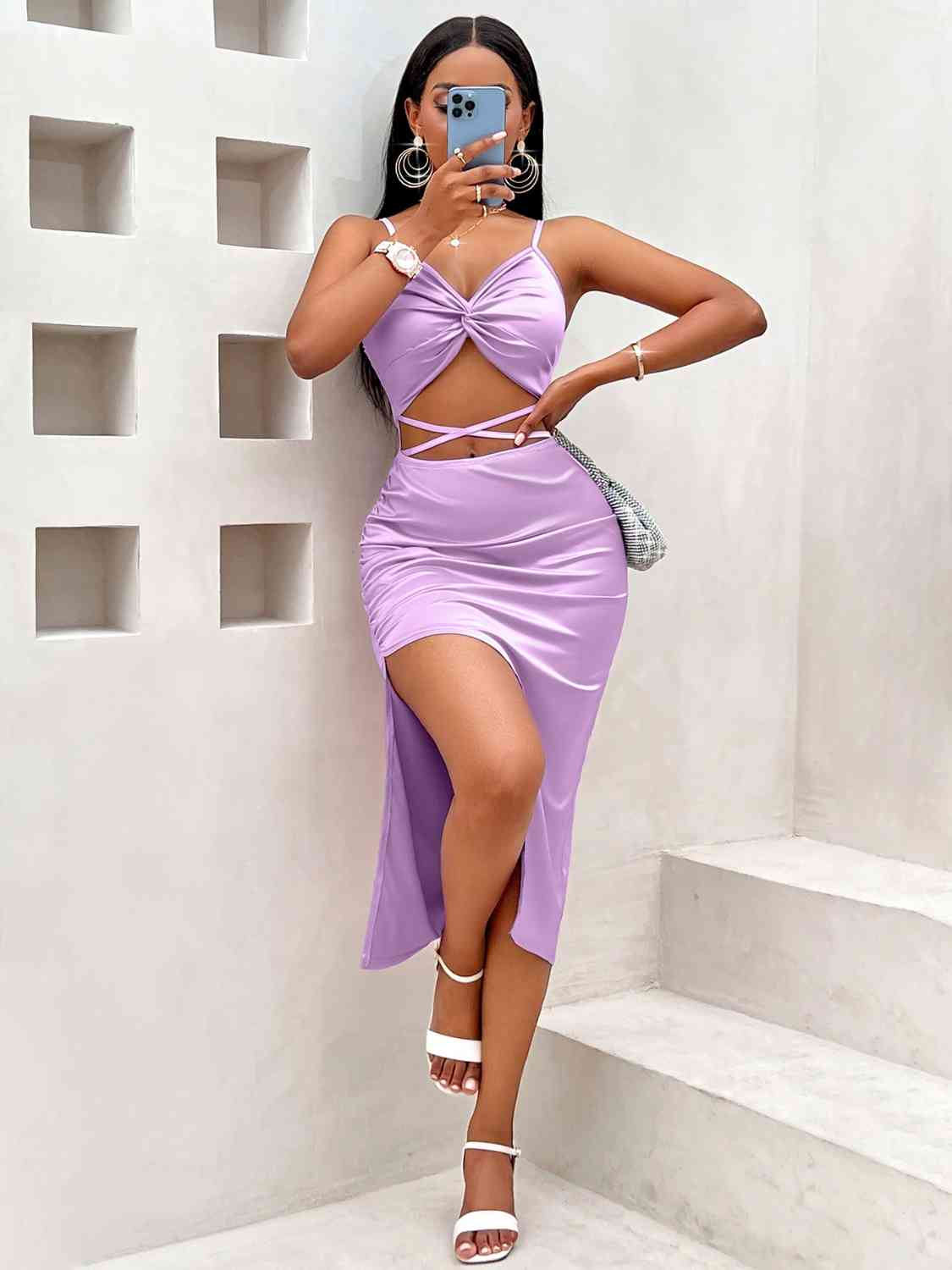 A chic dress with a unique twisted detail leading to a leg-revealing split, blending contemporary design with classic appeal.