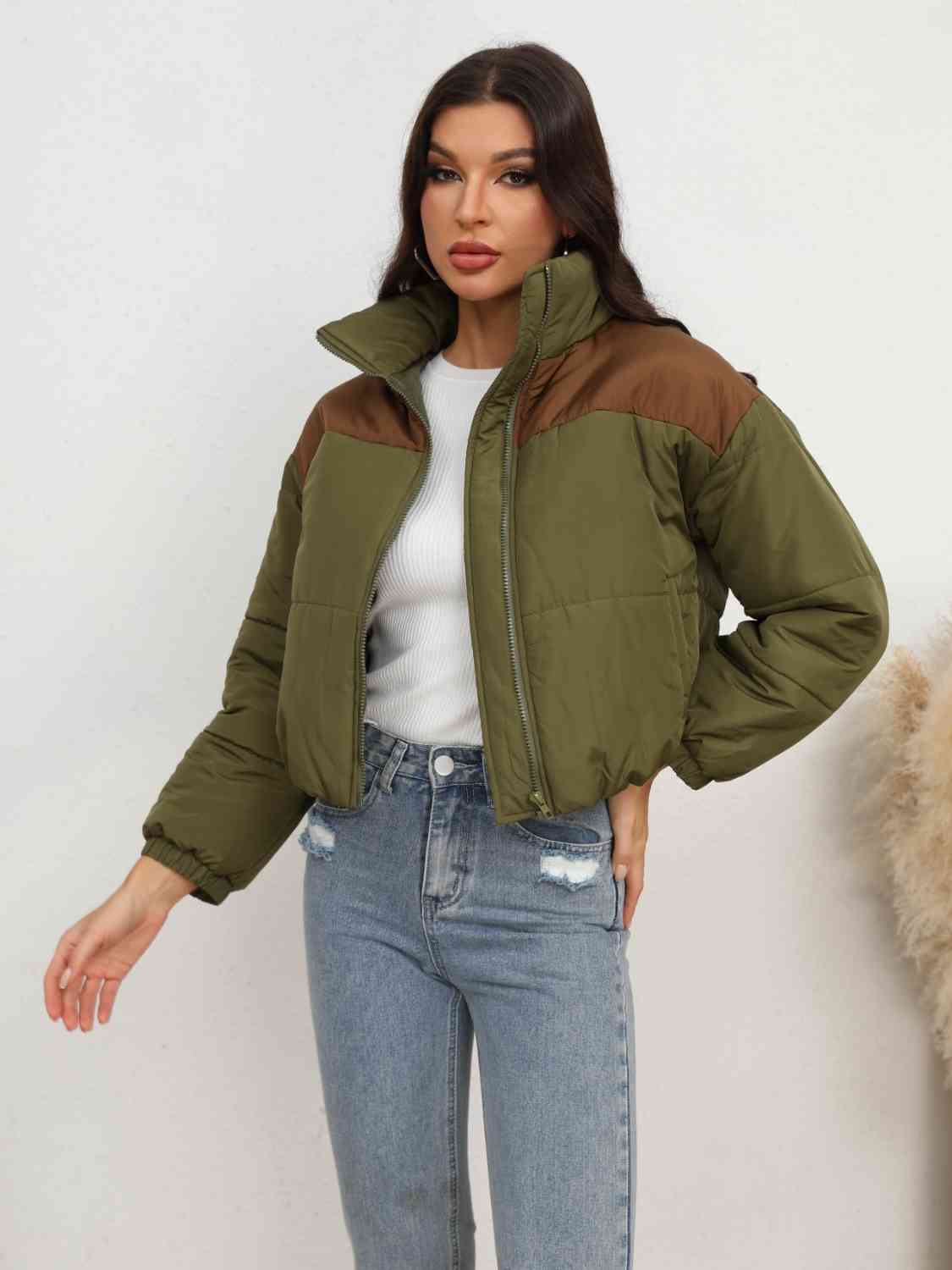 A 'Zip-Up Puffer Jacket,' a cold-weather outerwear piece designed for insulation and warmth, typically featuring a zipper closure for easy wear and a quilted puffer design for added insulation and style.