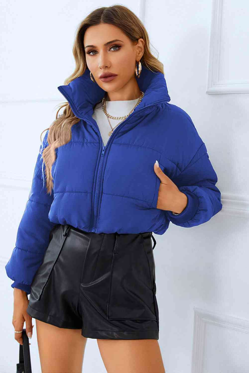 a warm and stylish winter coat in a rich, deep shade of navy blue. The coat features a faux fur-lined hood, zippered front, and ample pockets for added convenience. Perfect for staying cozy and fashionable during the cold winter months.