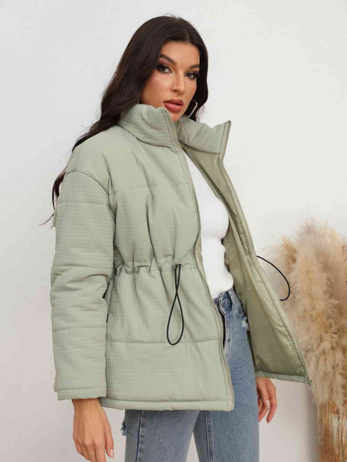 A "Waist Zip-Up Jacket" refers to a type of jacket with a zipper closure that runs along the waist area. This design allows for easy wear and removal and often provides a fitted and stylish look.